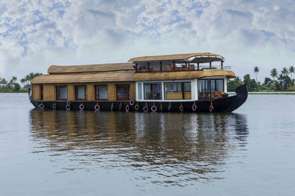 Premium glass-covered houseboat for cruise in Alappuzha.